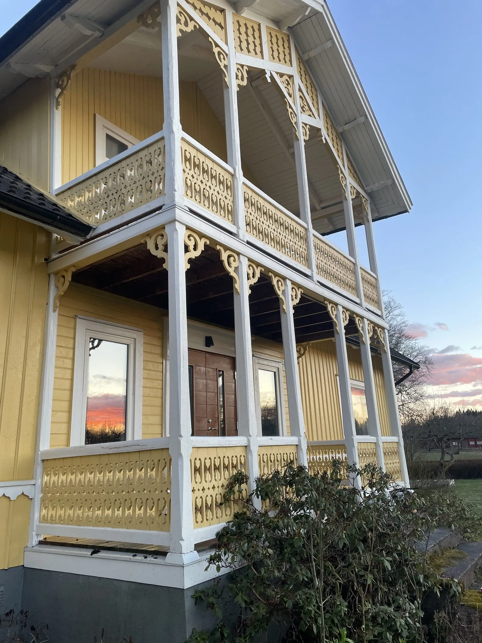 Samma fasad efter softwash — snickerierna är vita och panelen ren
